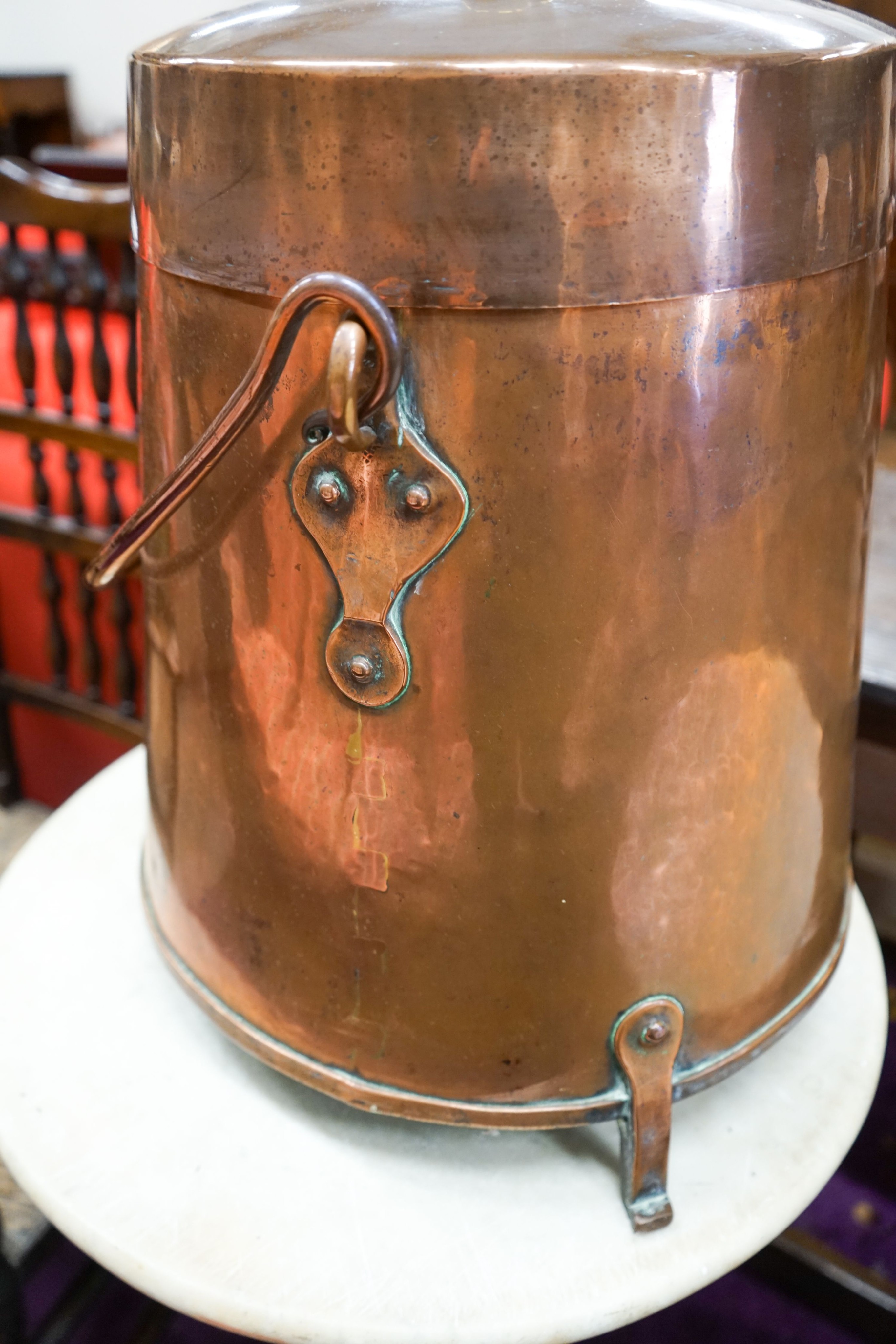 A Dutch copper milk churn and cover, having brass knop finial and swing handle on three feet, height 55cm